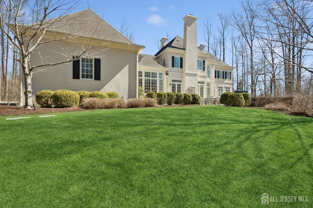 56 Cradle Rock Rd, Princeton, NJ 08540 - rear view of house with stucco siding, a yard, a chimney, and roof with shingles