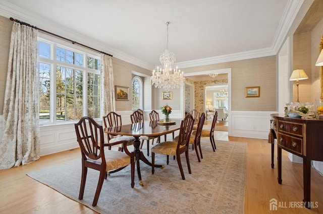 56 Cradle Rock Rd, Princeton, NJ 08540 - dining area with light wood-style floors, a chandelier, crown molding, a wainscoted wall, and a decorative wall
