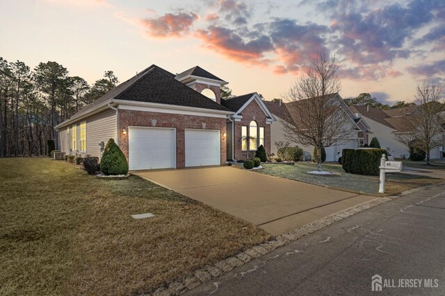 view of front of home with a garage and a yard