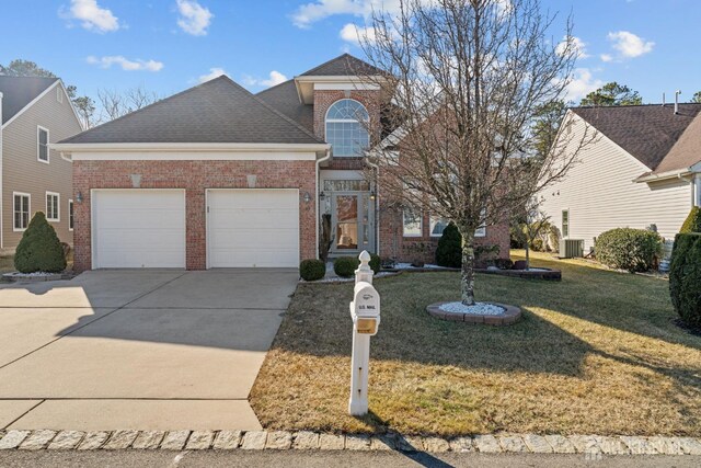 view of property featuring a garage and a front lawn