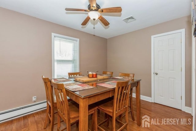 dining area with a ceiling fan, baseboards, visible vents, a baseboard heating unit, and light wood-type flooring