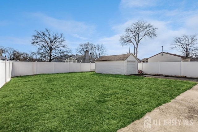 view of yard featuring an outbuilding, a fenced backyard, and a garage