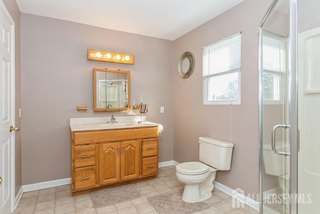 bathroom featuring baseboards, toilet, a stall shower, and vanity