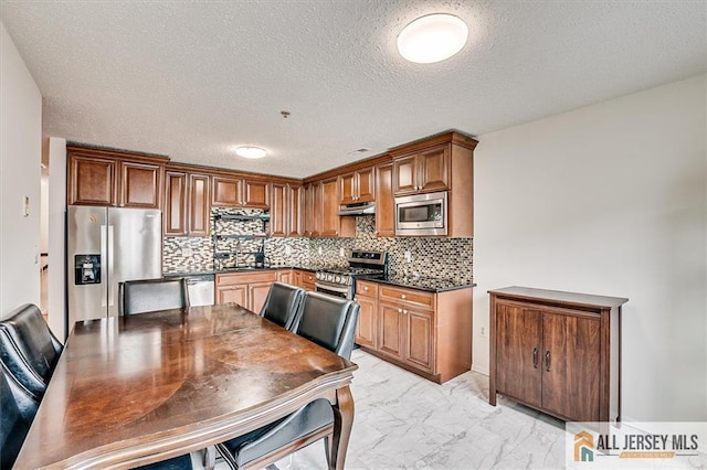 32 Prestwick Way Unit 32, Edison, NJ 08820 - kitchen featuring appliances with stainless steel finishes, under cabinet range hood, dark countertops, light marble finish floors, and decorative backsplash
