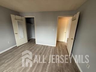 2112 Ravens Crest Dr, Plainsboro, NJ 08536 - unfurnished bedroom with baseboards, a closet, and wood finished floors