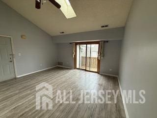 2112 Ravens Crest Dr, Plainsboro, NJ 08536 - empty room with vaulted ceiling with skylight, baseboards, ceiling fan, and wood finished floors