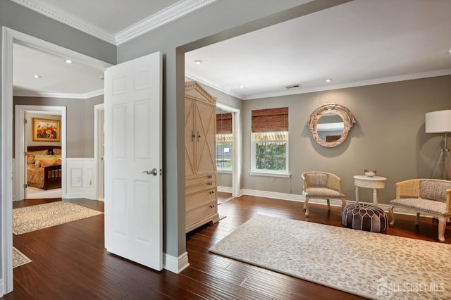 sitting room featuring ornamental molding and dark wood-type flooring