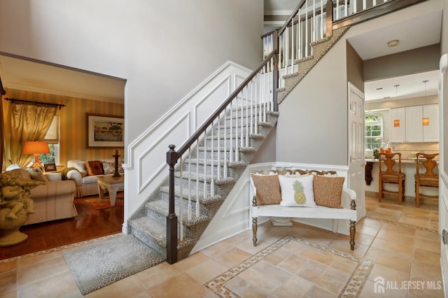 stairs with tile patterned flooring and a high ceiling