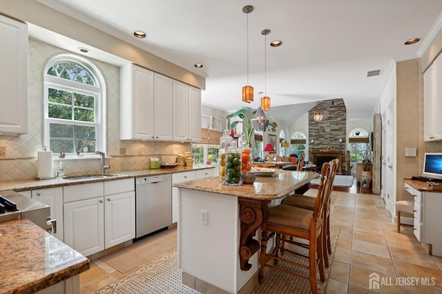 kitchen with dishwasher, decorative light fixtures, a kitchen island, and white cabinets