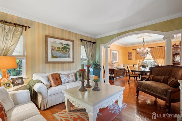 living room with decorative columns, ornamental molding, light hardwood / wood-style floors, and a notable chandelier