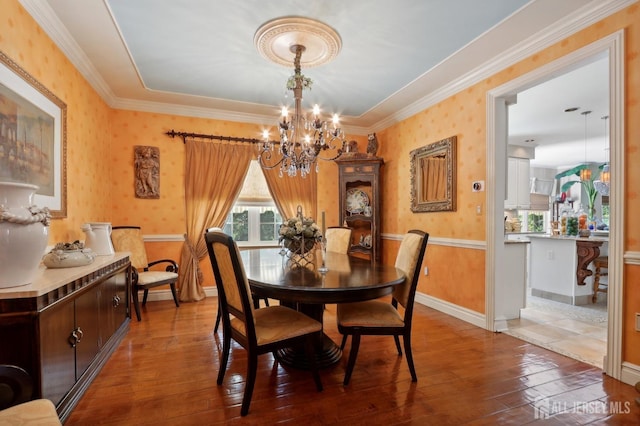 dining space with a chandelier, crown molding, and wood-type flooring