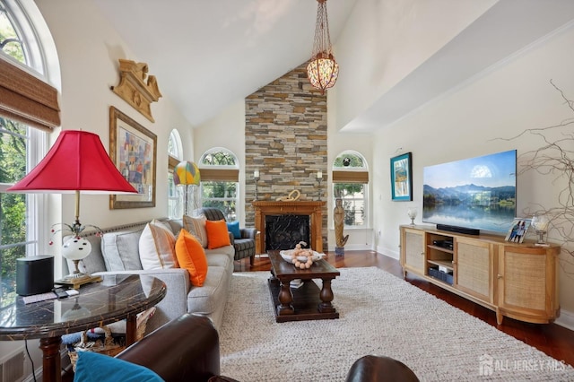 living room with a notable chandelier, a fireplace, dark wood-type flooring, and high vaulted ceiling