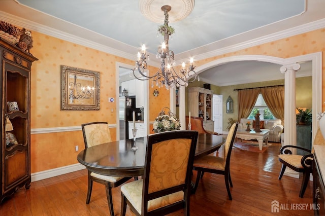 dining area with wood-type flooring, crown molding, and a chandelier