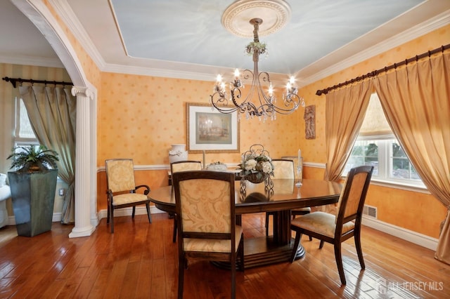 dining space featuring ornamental molding, a notable chandelier, and hardwood / wood-style flooring