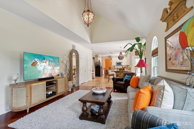 living room featuring hardwood / wood-style floors, high vaulted ceiling, and a notable chandelier