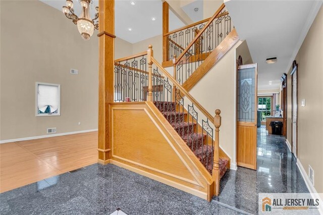 10 Signal Ct, South Brunswick, NJ 08810 - stairway featuring granite floors, baseboards, a chandelier, and a high ceiling