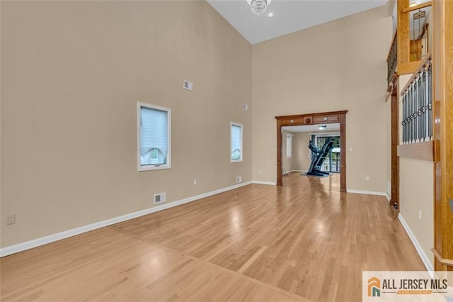 10 Signal Ct, South Brunswick, NJ 08810 - unfurnished living room with light wood-style floors, baseboards, and a high ceiling