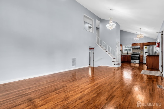 34 Sims Rd, Edison, NJ 08817 - unfurnished living room with a chandelier, dark wood-style floors, stairway, and high vaulted ceiling