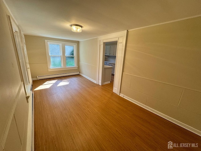 unfurnished bedroom with wood-type flooring and a baseboard radiator