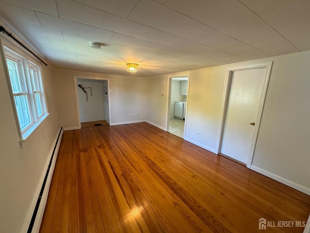 empty room with a baseboard radiator and wood-type flooring