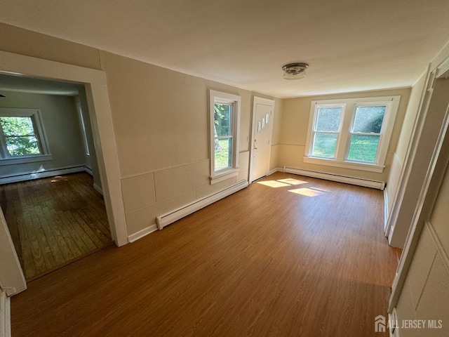 empty room featuring a baseboard radiator and hardwood / wood-style floors