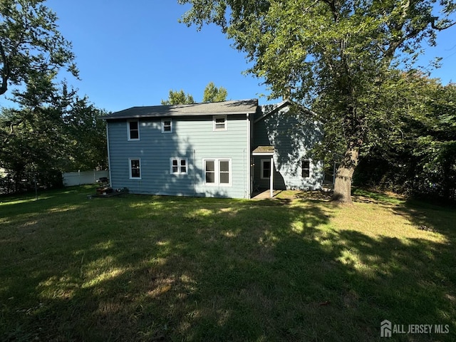 rear view of house featuring a yard