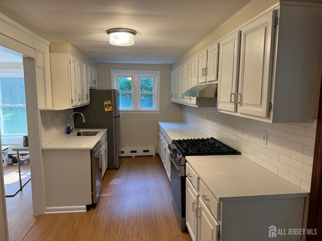 kitchen with sink, decorative backsplash, white cabinetry, and appliances with stainless steel finishes