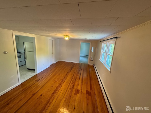 unfurnished room featuring light wood-type flooring and a baseboard radiator