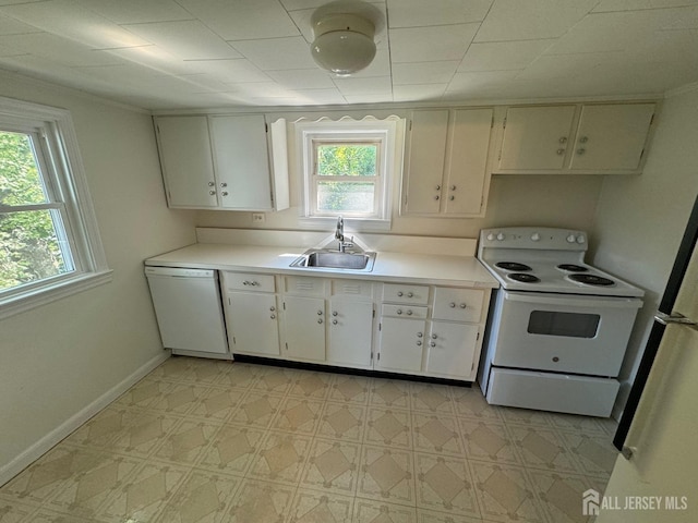 kitchen featuring sink, white appliances, and white cabinetry