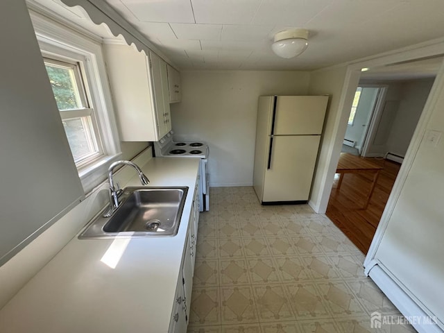 kitchen featuring white appliances, white cabinets, a baseboard radiator, and sink