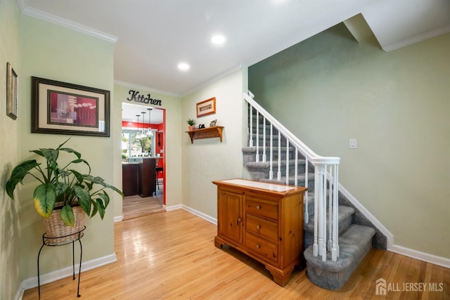 stairway with wood finished floors, baseboards, crown molding, and recessed lighting