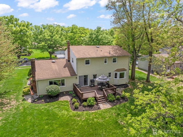 rear view of house featuring a wooden deck, a chimney, and a lawn