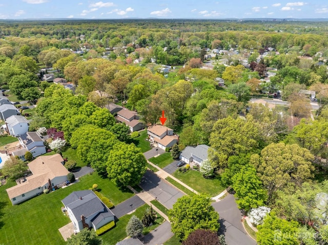 view of property location with a forest and nearby suburban area