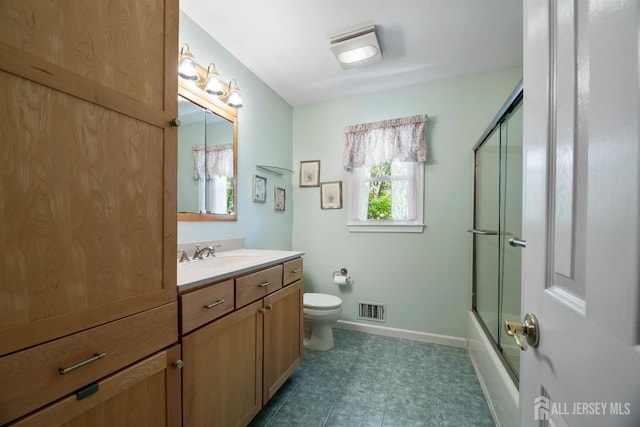 full bath featuring vanity, toilet, baseboards, and bath / shower combo with glass door