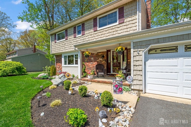 view of front of home featuring covered porch, brick siding, a front lawn, and an attached garage
