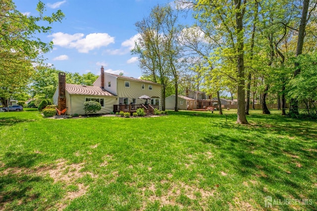 view of grassy yard featuring a wooden deck