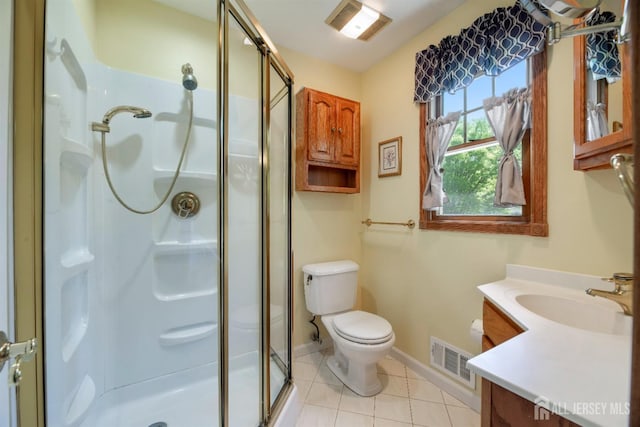 bathroom featuring a stall shower, vanity, baseboards, toilet, and tile patterned flooring