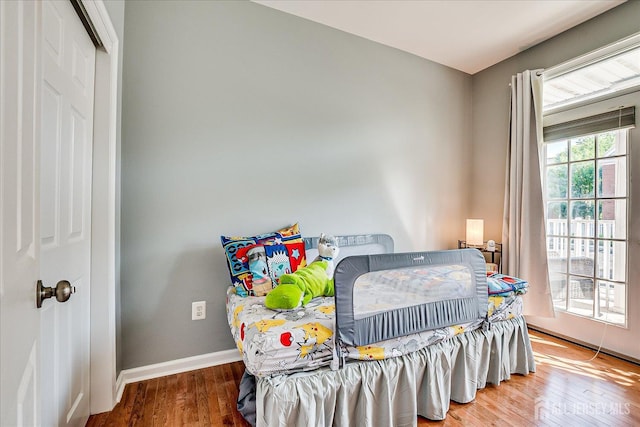 bedroom featuring wood finished floors and baseboards