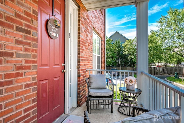 doorway to property featuring brick siding and a porch