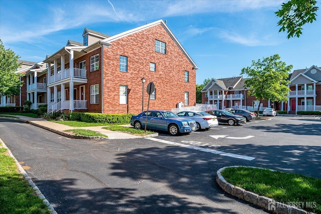view of front of house featuring uncovered parking and brick siding