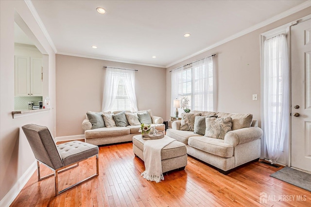 living room featuring light wood-type flooring, crown molding, baseboards, and recessed lighting