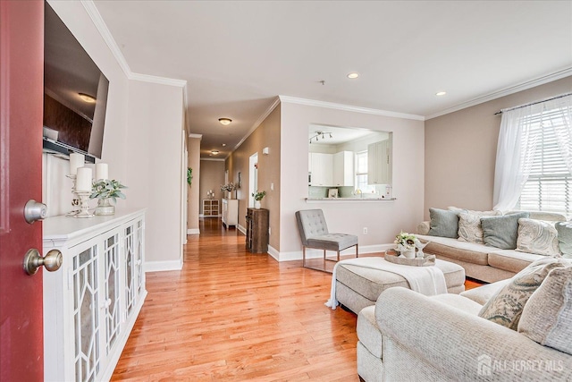 living room with light wood-type flooring, plenty of natural light, crown molding, baseboards, and recessed lighting