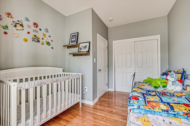 bedroom featuring wood finished floors, a closet, and baseboards