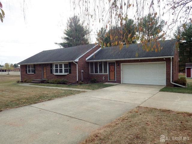 ranch-style home with driveway, roof with shingles, an attached garage, a front yard, and brick siding