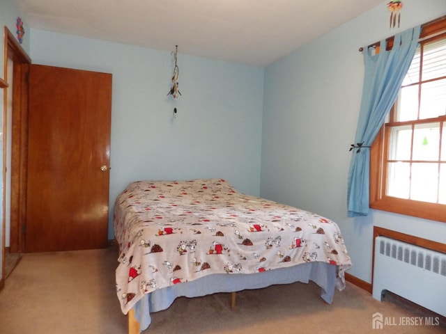 bedroom featuring radiator and light colored carpet