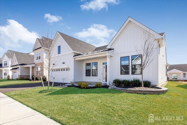 modern farmhouse style home featuring a garage, board and batten siding, driveway, and a front yard