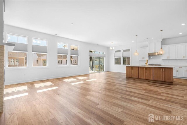 unfurnished living room featuring recessed lighting, baseboards, and light wood-type flooring