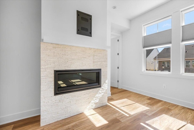 room details with wood finished floors, a fireplace, and baseboards