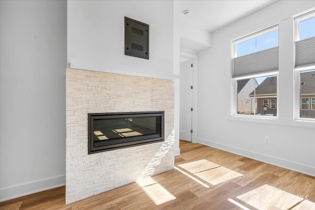 interior space featuring baseboards, wood finished floors, and a fireplace