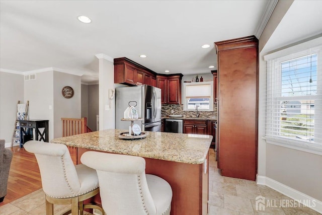 16 Dutch Valley Rd, Howell, NJ 07731 - kitchen with appliances with stainless steel finishes, reddish brown cabinets, baseboards, a sink, and a breakfast bar